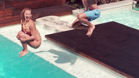 Couple-jumping-into-swimming-pool-making-huge-splash