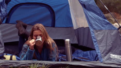 Woman-enjoying-hot-drink-in-her-tent