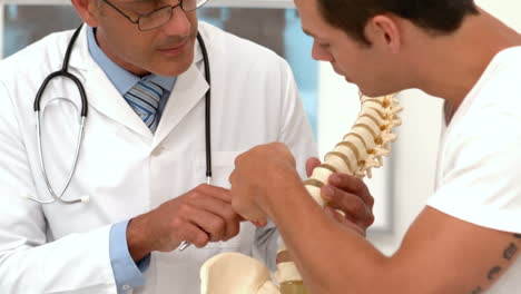 Doctor-showing-spine-model-to-patient