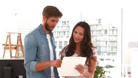 Casual-business-workers-looking-at-clipboard