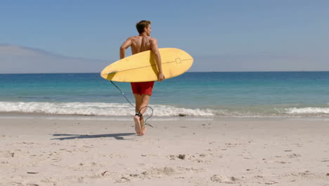 Un-Hombre-Guapo-Corriendo-En-El-Agua-Con-Una-Tabla-De-Surf.