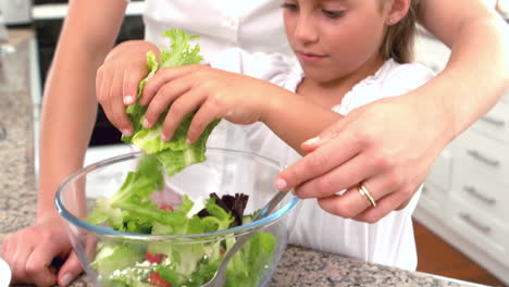 Mother-and-daughter-preparing-salad-together-