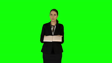 Businesswoman-showing-book-to-camera-on-green-office-