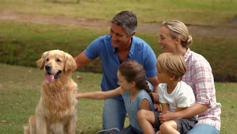 Familia-Feliz-Sonriendo-A-La-Cámara-Con-Su-Perro