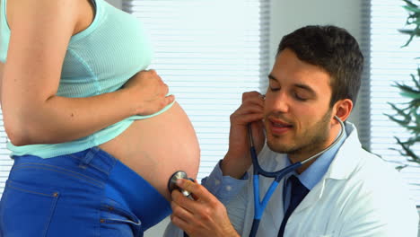 Doctor-Escuchando-El-Estómago-De-Una-Mujer-Embarazada.