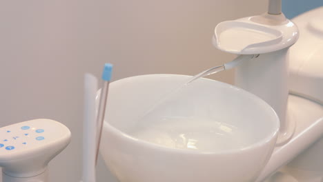 Close-up-of-dental-sink-with-flowing-water