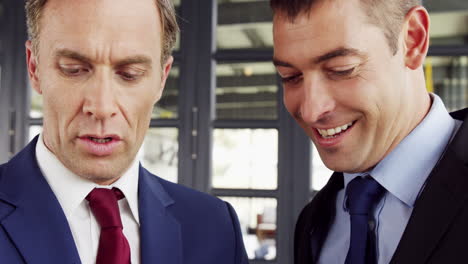 Businessmen-talking-together-while-looking-folder