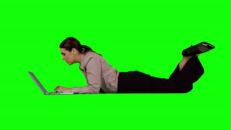 Businesswoman-using-laptop-against-green-screen