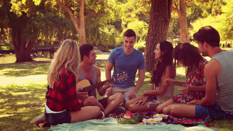 Happy-friends-in-the-park-having-picnic-and-playing-guitar