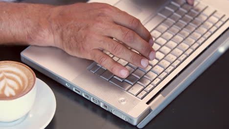 Close-up-view-of-man-typing-on-his-laptop-