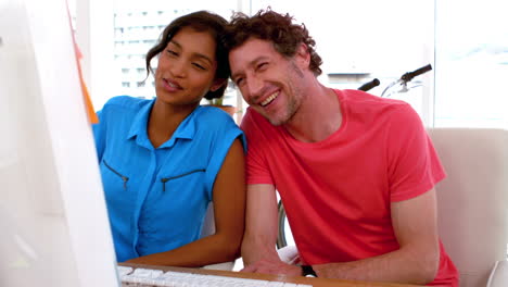 Happy-business-couple-working-on-a-computer