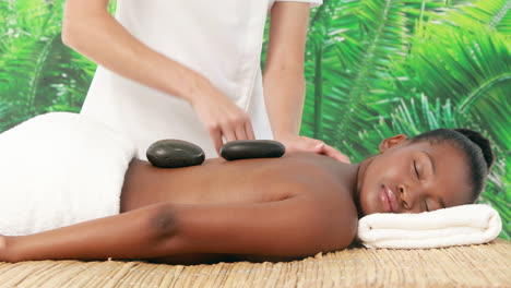 Smiling-brunette-getting-hot-stone-massage
