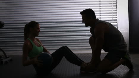 Fitte-Frau-Macht-Sit-ups-Mit-Gewichten-Mit-Trainer