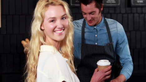 -Smiling-waiter-serving-a-coffee-to-a-customer
