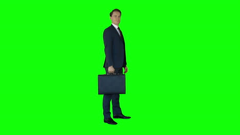 Businessman-standing-on-green-screen-with-suitcase