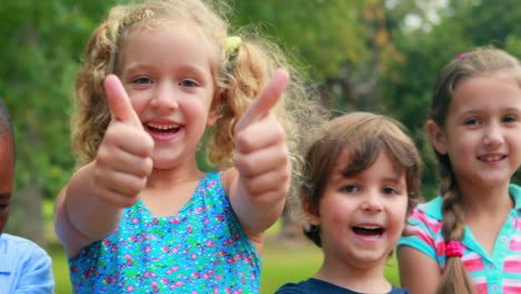 Happy-children-looking-at-camera-with-thumbs-up-