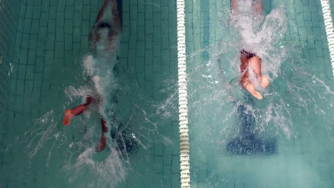 Above-view-of-swimmers-diving-into-pool