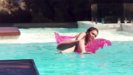 Attractive-woman-on-a-lilo-in-swimming-pool