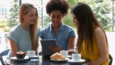 Bonitos-Estudiantes-Pasando-El-Rato-En-La-Cafetería-Del-Campus-Usando-Una-Tableta.