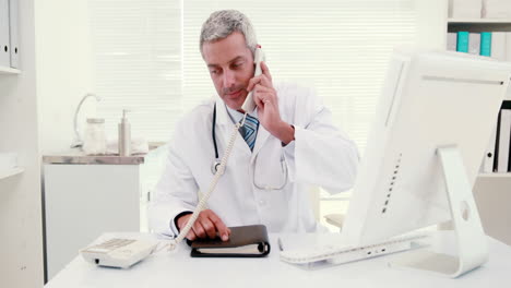 Doctor-phoning-and-using-computer-