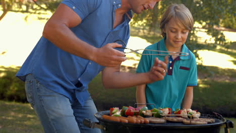 Happy-father-doing-barbecue-with-his-son