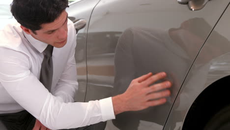 businessman-checking-the-cars-paint-job