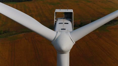Wind-Turbine-Close-Up-Aerial-Drone-Shot-with-Farmland-Scenery-in-the-Background
