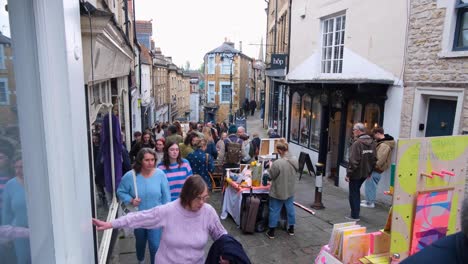 People-visiting-and-shopping-at-the-Frome-Farmers-Market-with-stalls-of-local-independent-vendors-selling-arts-and-crafts-in-Somerset,-England