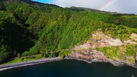 Drone-shot-of-the-coast-of-Maui,-Hawaii,-with-a-rainbow-in-the-background