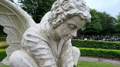 Kreisender-Geflügelter-Engeljunge-Aus-Marmor,-Nahaufnahme-Einer-Gedenkskulptur-Im-Friedhofs-Gedenkgarten