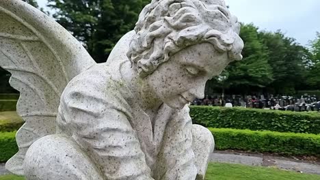 Ángel-De-Mármol-Alado-Dando-Vueltas-Cerca-De-La-Escultura-Conmemorativa-En-El-Jardín-Conmemorativo-Del-Cementerio