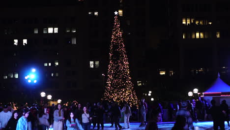 Los-Angeles-USA,-People-Ice-Skating-on-Ice-Rink-at-Pershing-Square-During-Christmas-Holidays-at-Night,-Slow-Motion