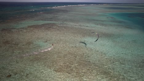 A-kite-surfer-glides-over-the-clear,-shallow-waters-of-Cayo-Vapor-on-a-sunny-day