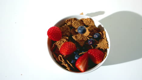 Strawberries-and-blueberries-falling-in-a-wheat-cereals-bowl