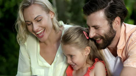 Retrato-De-Una-Linda-Familia-Mirando-Una-Computadora-Portátil-Y-Sonriendo