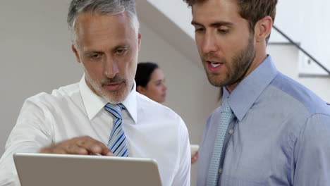 Businessman-talking-in-front-of-the-camera-while-businesswoman