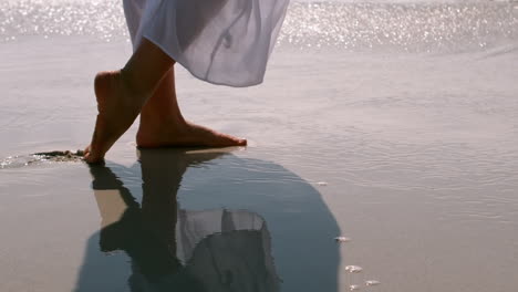 Woman-walking-on-the-wet-sand