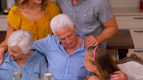 Cute-family-standing-in-front-of-the-kitchen-table