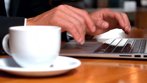 Hombre-De-Negocios-Trabajando-En-Una-Computadora-Portátil-Mientras-Toma-Café