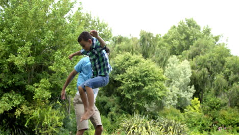 Glücklicher-Vater-Und-Sohn-Spielen-Auf-Dem-Trampolin-