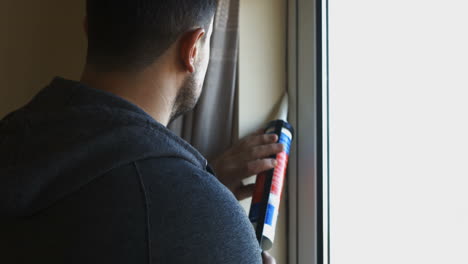 Handyman-filling-in-tiles-to-window