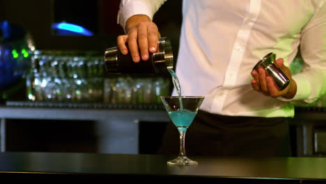 Handsome-barman-preparing-a-blue-cocktail
