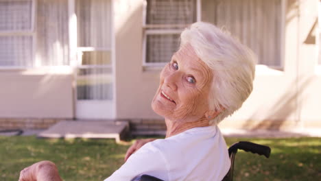 Senior-woman-sitting-on-a-wheelchair-in-the-backyard