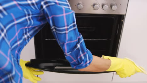 Woman-front-the-back-cleaning-the-oven