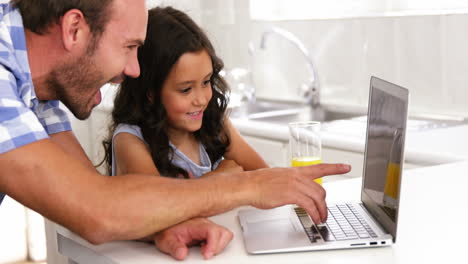Daughter-and-father-laughing-in-front-of-a-laptop