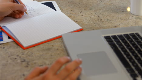Mujer-Usando-Cuaderno-Y-Computadora-Portátil