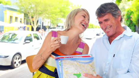 Smiling-couple-drinking-coffee-and-checking-the-map