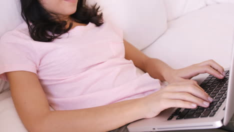 Mujer-Sentada-En-Un-Sofá-Usando-Su-Computadora-Portátil