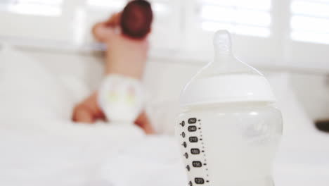 Close-up-on-baby''s-bottle-with-the-baby-on-background