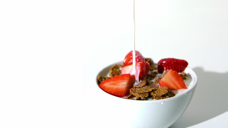 Milk-falling-in-a-wheat-cereals-and-strawberries-bowl